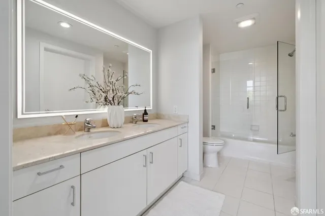 a bathroom with a granite countertop sink a toilet and shower