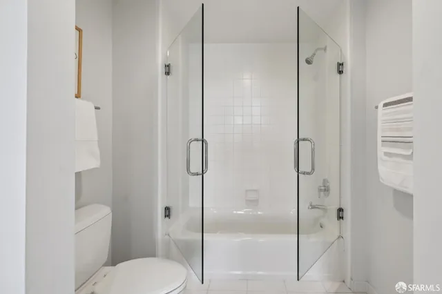 a white toilet next to a bathroom