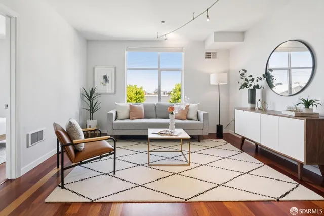 a living room with furniture a table and a potted plant