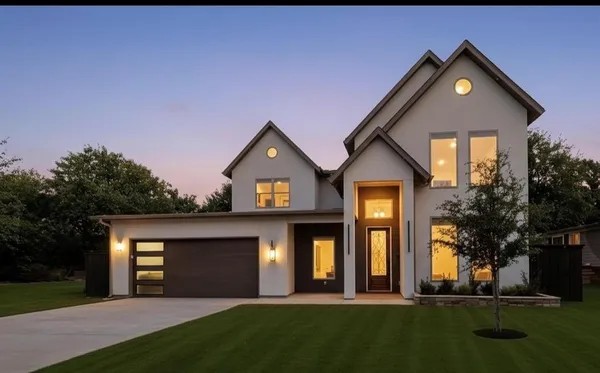 a front view of a house with a yard and trees