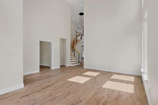 an empty room with wooden floor and white walls