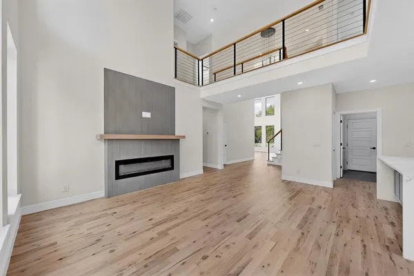 a view of a hallway with wooden floor and a kitchen