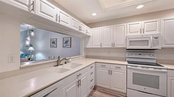 a kitchen with white cabinets and white appliances