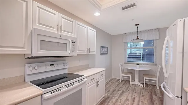 a kitchen with white cabinets and white appliances