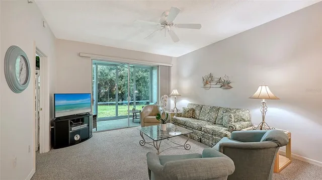a living room with furniture a fireplace and a large window