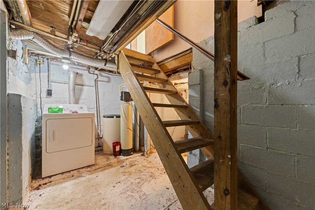 409 Edith Avenue Akron, OH 44312 - Photo 25 of 45 Wooden staircase with open risers, concrete block walls, exposed ceiling joists, and a utility area featuring a water softener