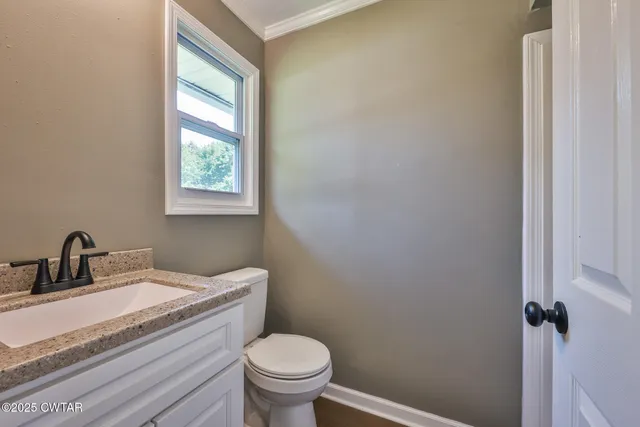 a bathroom with a granite countertop sink toilet and a mirror