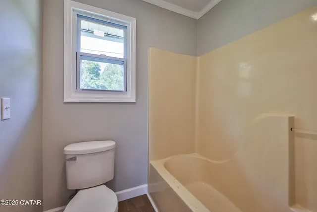 a white toilet sitting next to a bath tub