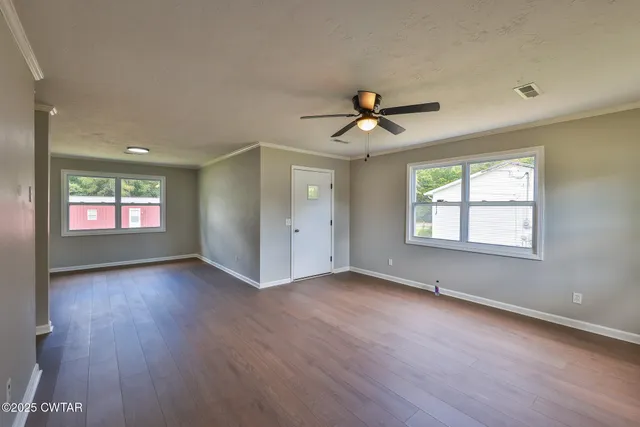 wooden floor in an empty room with a window