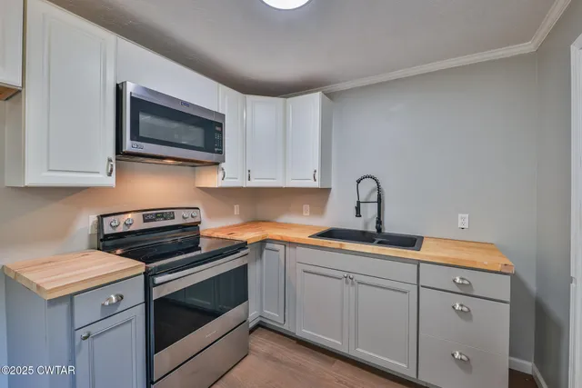 a kitchen with white cabinets stainless steel appliances and sink