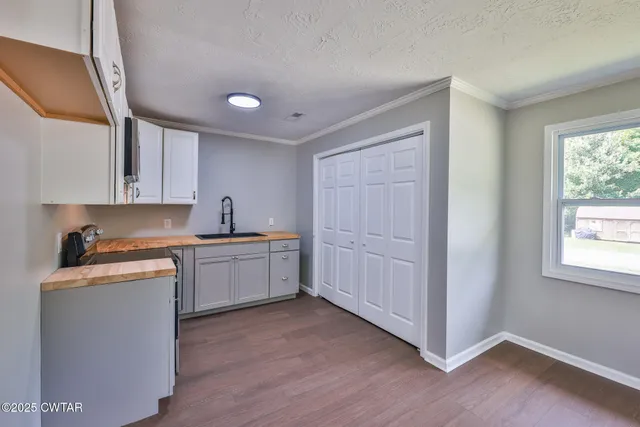 a kitchen with a sink cabinets and wooden floor