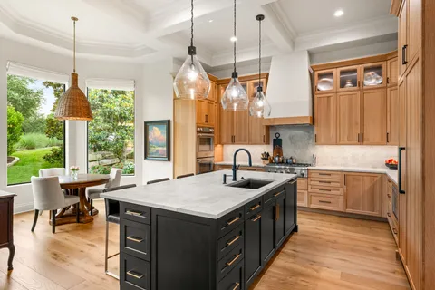 a kitchen with a stove a sink a center island and living room view