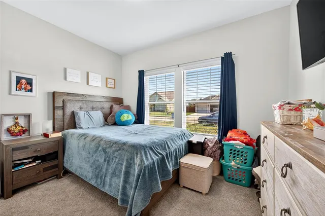 a bedroom with a bed and a table chair