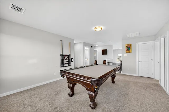 a room with pool table and windows