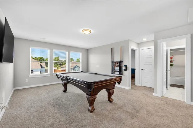 a room with furniture pool table and a flat screen tv