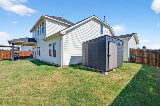 a view of a house with a yard and wooden fence