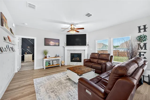 a living room with furniture a flat screen tv and a fireplace