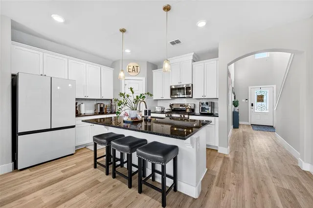 a kitchen with stainless steel appliances a stove a sink a refrigerator and a oven