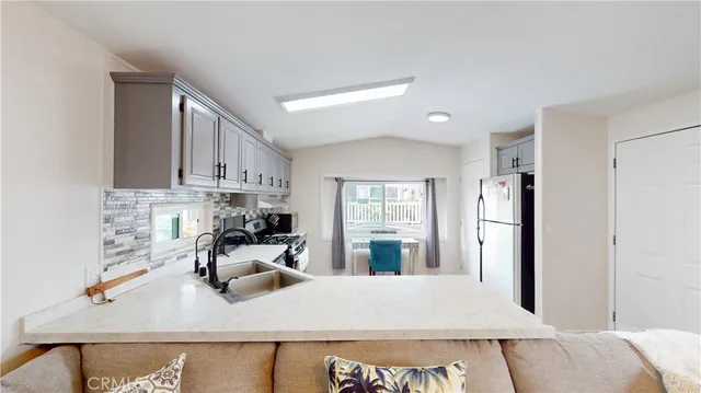 a kitchen with stainless steel appliances granite countertop a sink refrigerator and cabinets