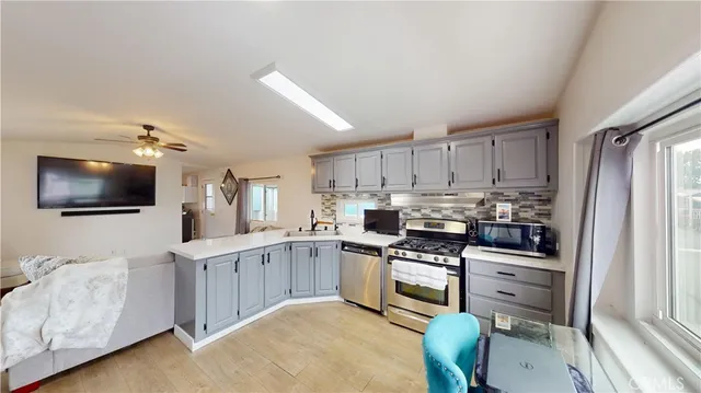 a kitchen with cabinets stainless steel appliances and a window