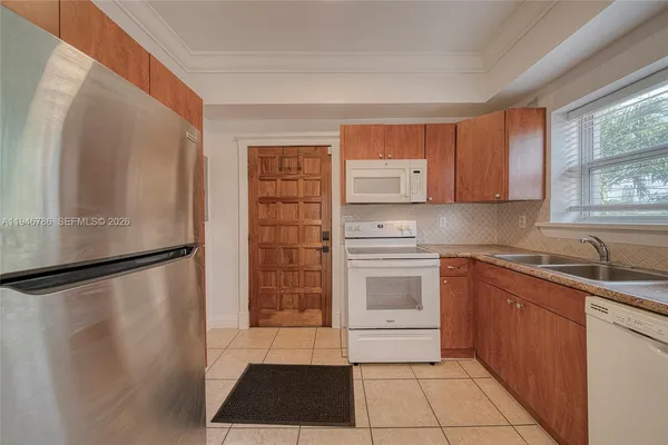 a kitchen with a refrigerator sink and cabinets