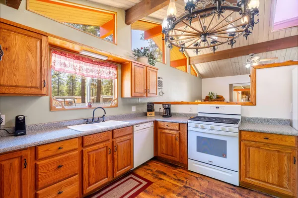 a kitchen with stainless steel appliances granite countertop a sink and cabinets with wooden floor
