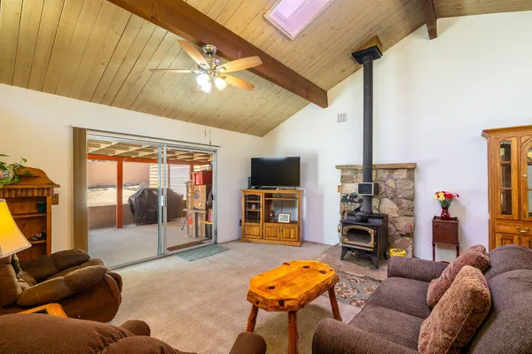 a living room with furniture a flat screen tv and a floor to ceiling window