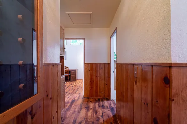 a view of a hallway with wooden floor and stairs