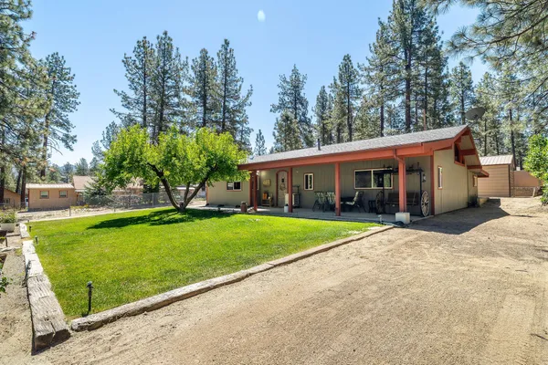 a view of a house with a yard and tree s