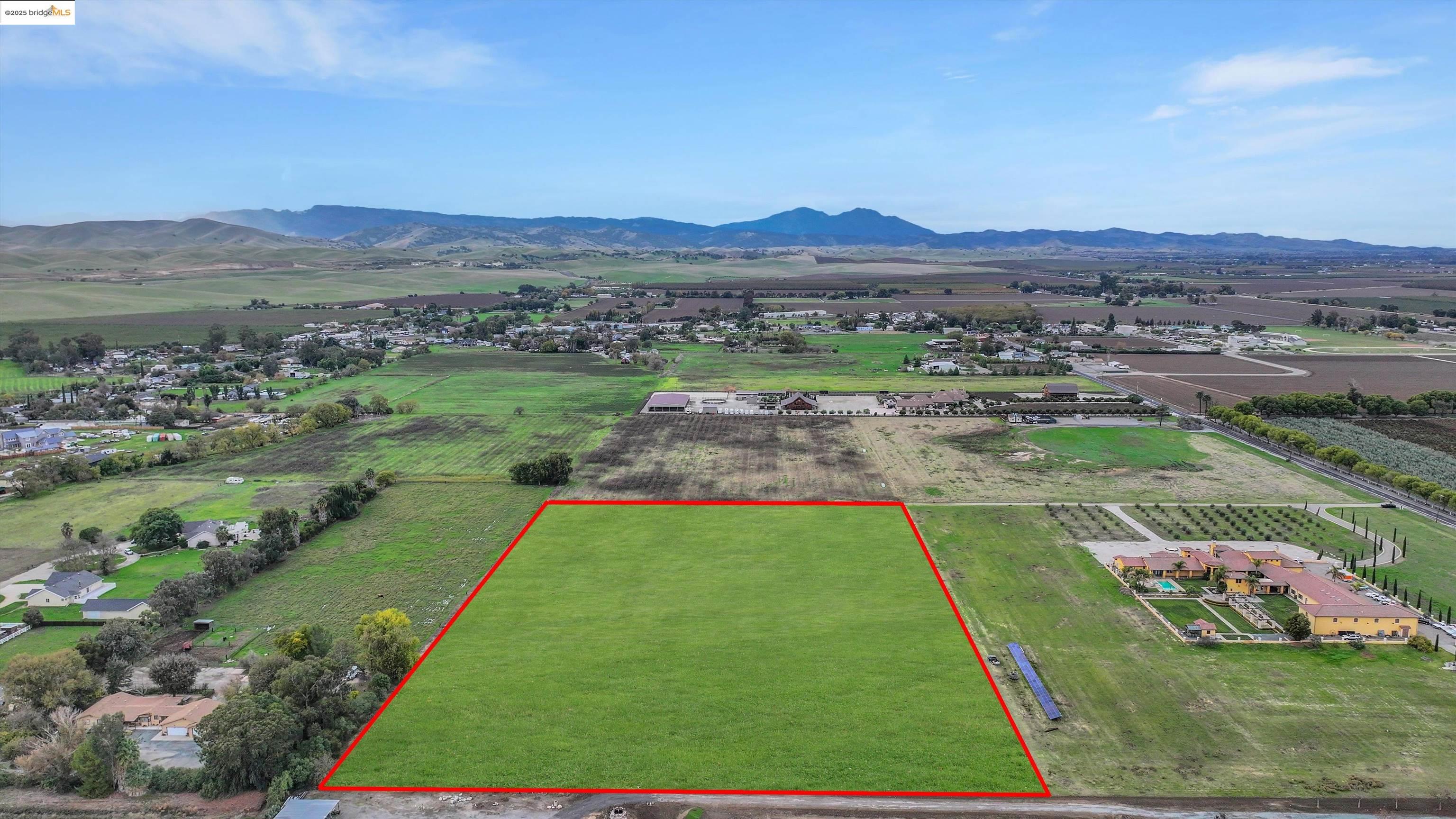 Overview of rural landscape with property boundaries highlighted and a mountainous background