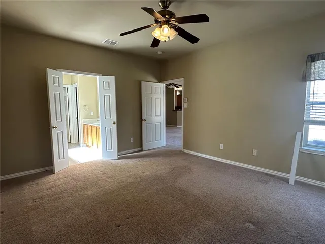 a view of a room with a ceiling fan and a window