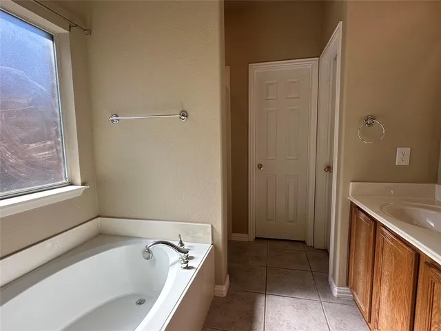 a bathroom with a tub a sink and a shower