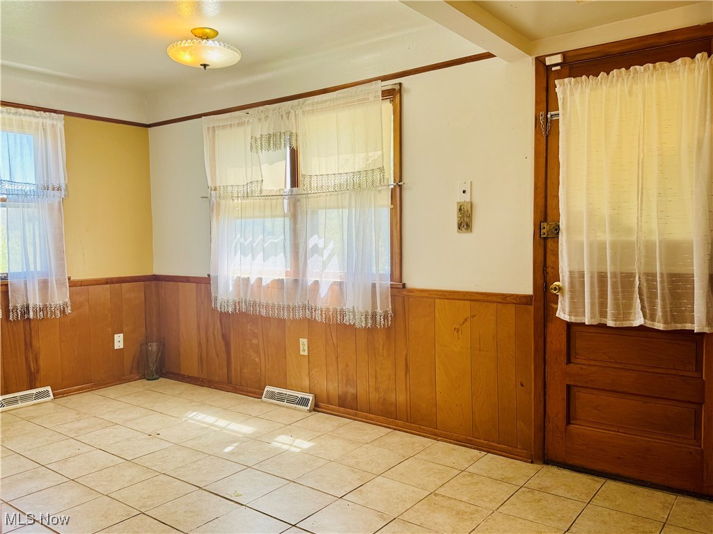 25911 Tryon Road Bedford, OH 44146 - Photo 12 of 49 Empty room with wood walls, visible vents, and wainscoting