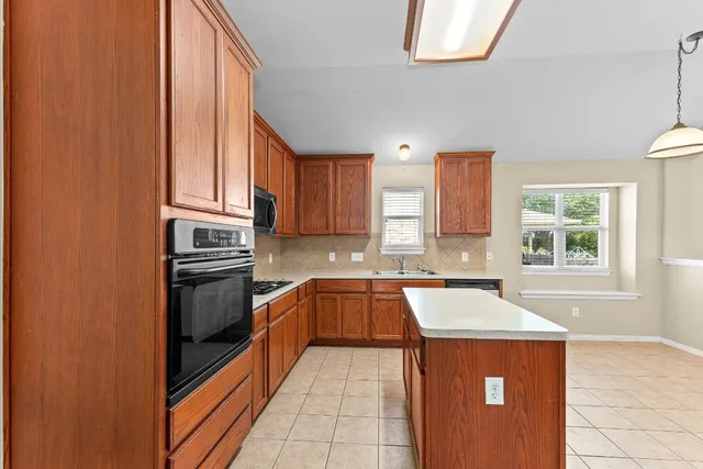 a kitchen with a sink a stove top oven and cabinets