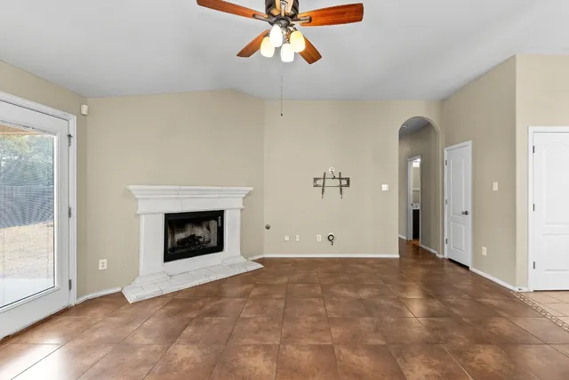 a view of an empty room with window and a fireplace