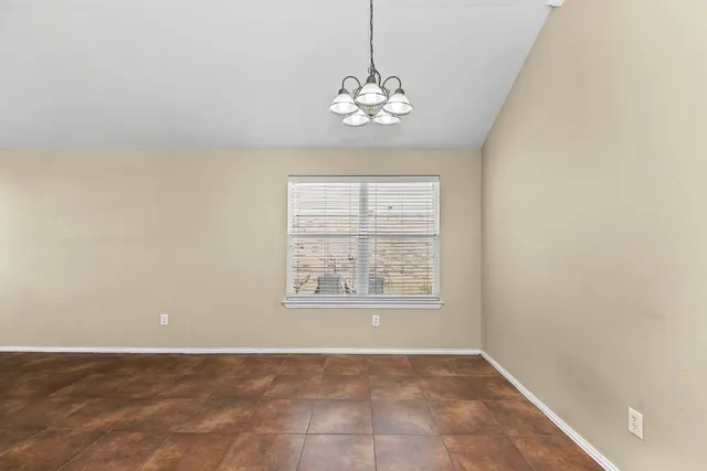 an empty room with windows and chandelier