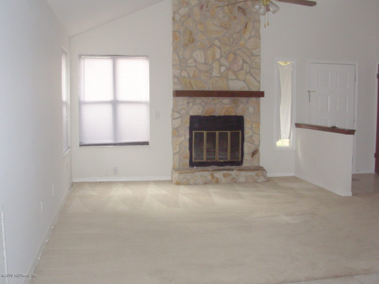 2107 Cornell Road Middleburg, FL 32068 - Photo 3 of 11 an empty room with a fireplace and windows