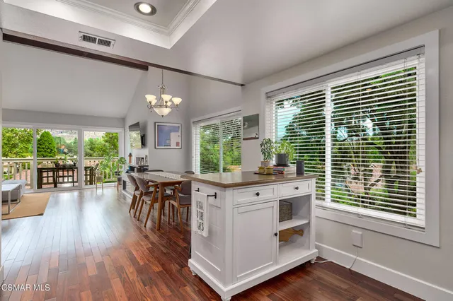 a kitchen with stainless steel appliances granite countertop white cabinets a stove a sink and a microwave