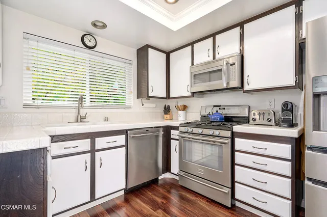 a kitchen with stainless steel appliances a refrigerator sink and cabinets