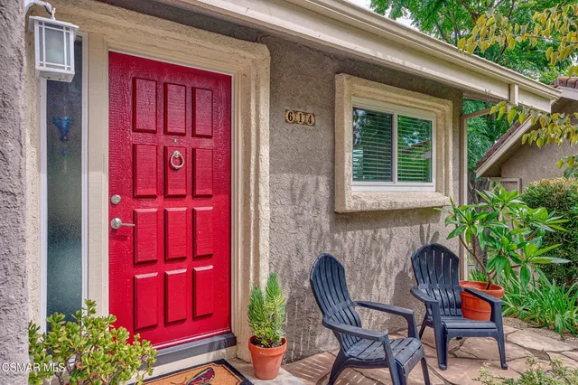 a view of patio with a table and chairs and a barbeque