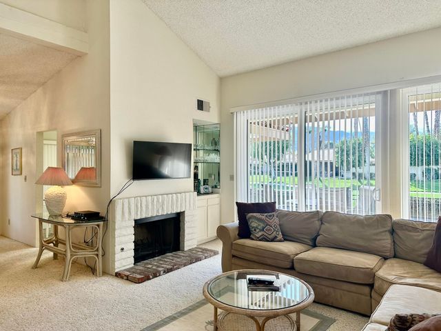 a living room with furniture a large window and a fireplace