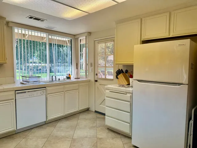 a kitchen with white cabinets and white appliances