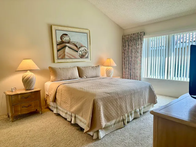 a bedroom with a bed and a painting on the wall