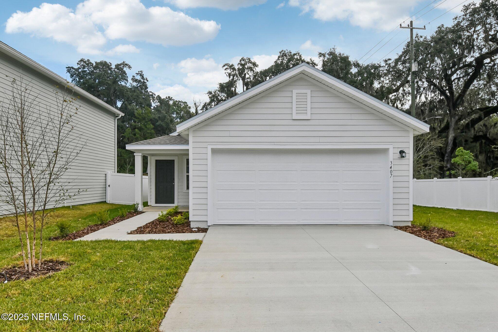 a front view of house with yard and trees in the background