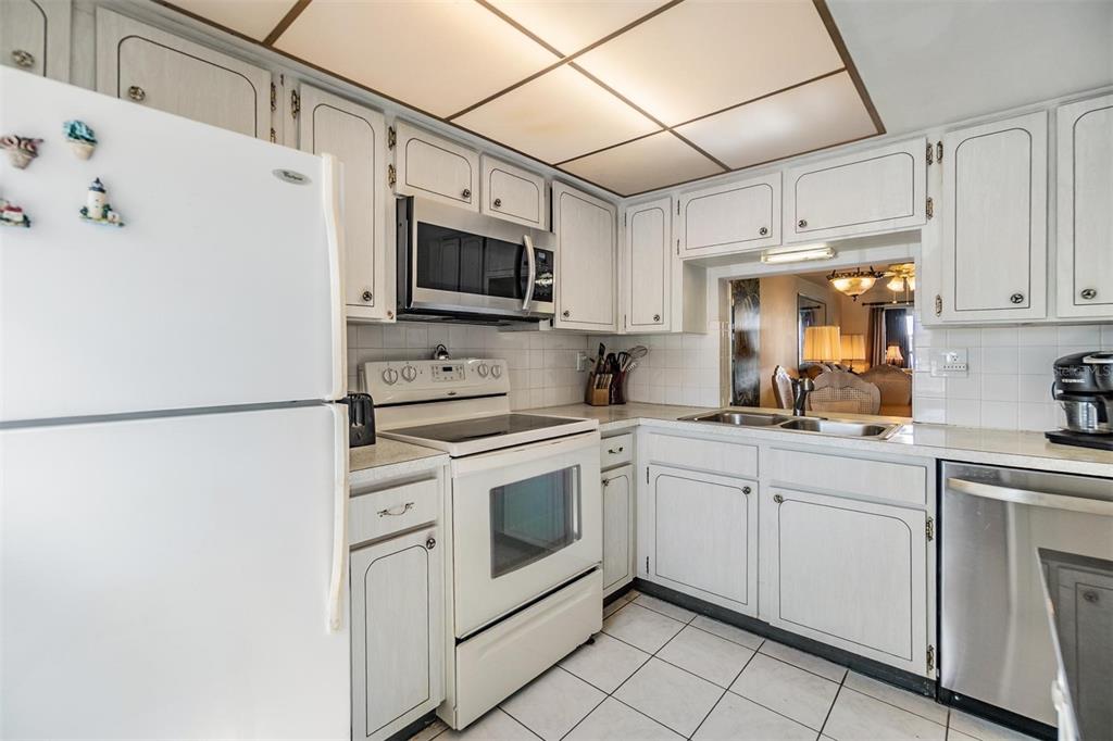 4215 Regal Place, Unit 4215 New Port Richey, FL 34652 - Photo 6 of 16 a kitchen with stainless steel appliances white cabinets and white appliances
