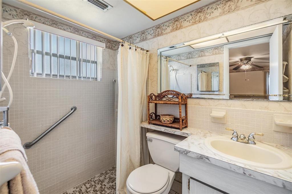 4215 Regal Place, Unit 4215 New Port Richey, FL 34652 - Photo 10 of 16 a bathroom with a toilet a sink and mirror