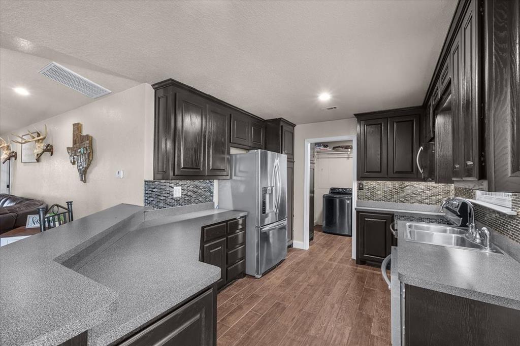 2250 Poolville Cut Off Road Springtown, TX 76082 - Photo 7 of 22 a kitchen with stainless steel appliances granite countertop a sink stove and refrigerator