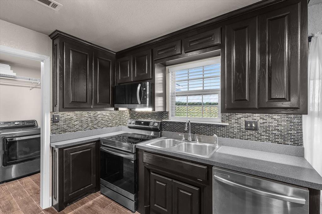 2250 Poolville Cut Off Road Springtown, TX 76082 - Photo 8 of 22 a kitchen with stainless steel appliances granite countertop a sink stove and oven