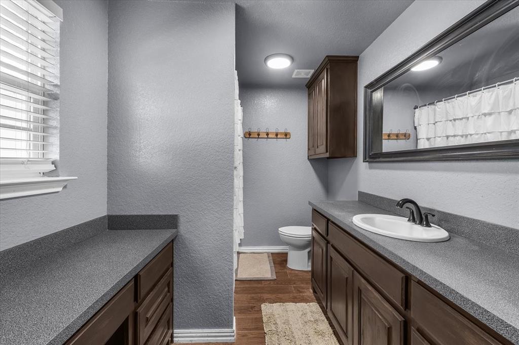 2250 Poolville Cut Off Road Springtown, TX 76082 - Photo 9 of 22 a bathroom with a sink a toilet and a mirror