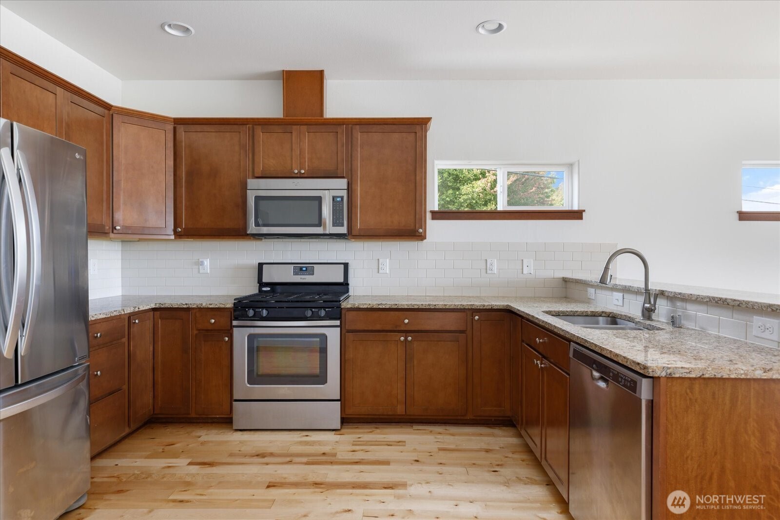 2119 20th Street Anacortes, WA 98221 - Photo 14 of 38 a kitchen with stainless steel appliances granite countertop a stove a sink dishwasher and a refrigerator